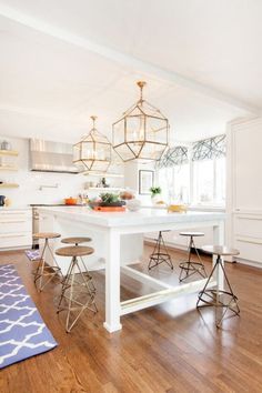 a kitchen island with stools in front of it and a chandelier hanging from the ceiling