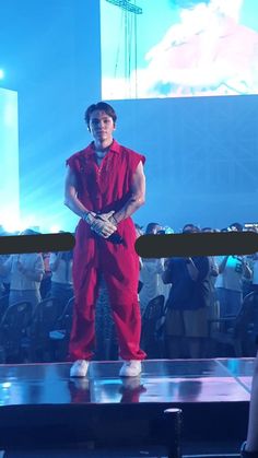 a man in red jumpsuit standing on stage