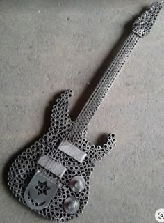 an intricately designed guitar is laying on the ground with its head resting on it's neck