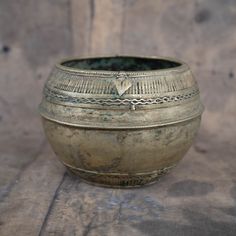 a metal bowl sitting on top of a wooden table