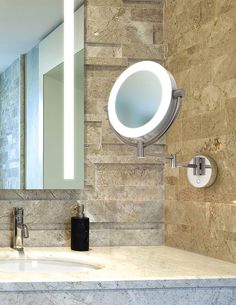 a bathroom sink with a lighted mirror above it