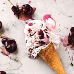 an ice cream cone with cherries on it