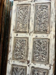 an old wooden door with intricate carvings on it's sides and the top panel is painted white