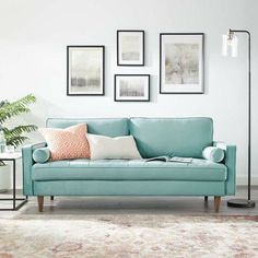 a living room with blue couches and pictures on the wall above them, along with a rug