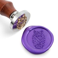 an owl wax stamp is next to a purple rubber stamp