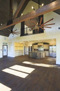 an open floor plan with wood floors and ceiling fans in the middle of the room