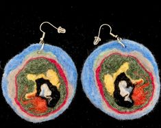 two circular earrings with colorful designs on them