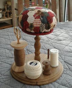 a table topped with lots of different types of thread and spools on top of a bed