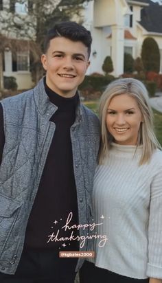 a young man and woman standing next to each other in front of a large house