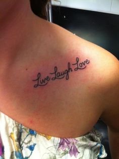 a woman with a tattoo on her shoulder that says live laugh love in cursive writing