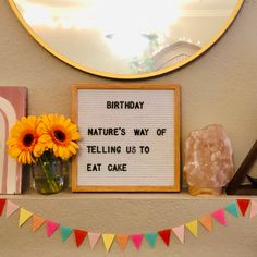 a birthday sign on a mantle with flowers in a vase and other decorations around it