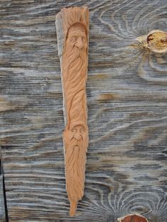 a carving of an old man with long hair and beard on a piece of wood