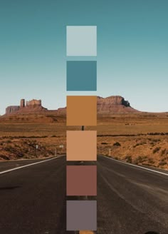 an empty road in the middle of nowhere with mountains in the background and blue sky