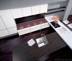 an overhead view of a kitchen with wooden floors and white cabinets, including a sink