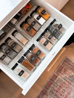 an organized spice drawer with spices and seasonings in it on top of a rug