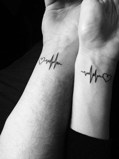 two wrist tattoos with heartbeats and heart on each one side, both in black ink