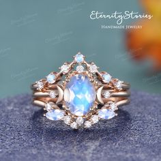 a ring with an oval shaped blue stone surrounded by smaller round white stones on top