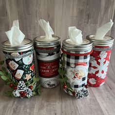 three christmas themed jars with tissue paper in them