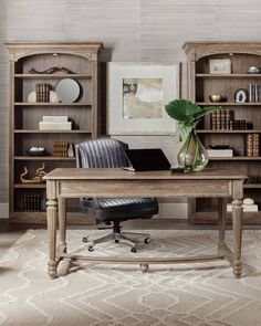 a desk with a chair and bookshelf in the background