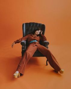 a woman sitting in a chair with her legs crossed and feet up on the ground