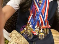 a woman sitting at a table with medals around her neck