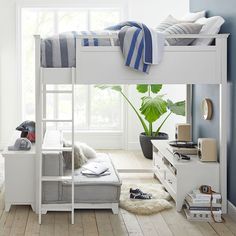 a white bunk bed sitting next to a window in a room with blue walls and wooden floors