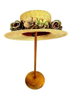 Romantic and elegant vintage style boater straw hat adorned with a composition of quality fabric flowers in shades of green and purple, attached to a 50 millimeter grosgrain ribbon.Made with 8/9 millimeters natural straw braid. Measurements in centimeters are 34 x 32. Crown height 9. Brim length 7. These measurements may have some slight variation depending on the size of the hat.For its elaboration we only use very good quality and resistant straw braids. In our workshop in the Pyrenees we sew Vintage Brown Straw Hat For Summer, Vintage Brown Straw Hat, Vintage Brown Panama Hat For Vacation, Brown Vintage Panama Hat For Vacation, Vintage Adjustable Hat Bands For Vacation, Vintage Brown Hat Bands For Summer, Vintage Beige Hat For Country Events, Vintage Natural Color Adjustable Hats, Adjustable Vintage Panama Hat