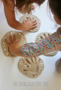 two children are playing with their handprints on the ground next to some cookies