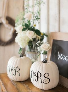 two white pumpkins with the word mr and mrs painted on them sitting on a table