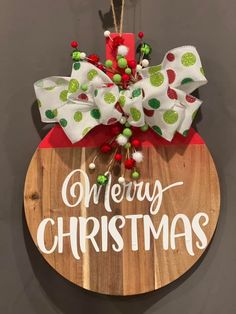 a christmas ornament hanging on the side of a wooden sign that says merry christmas