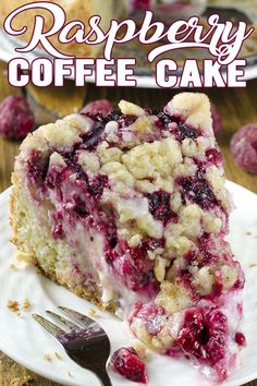 a piece of cake on a white plate with raspberries and crumbs