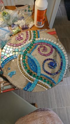 there are many items on the table that is covered in glass and marble mosaics