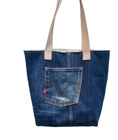 Diese einzigartige Handtasche wurde aus verschiedenen Teilen recycelter Jeans angefertigt und ist deshalb ein echtes Unikat. Gerade die Nutzungspuren der Jeans verleihen ihr ein besonders lässiges Aussehen. Die schräg geschnittene Klappe dient als „Hingucker" und verschließt die Tasche, die auch gut als Umhängetasche getragen werden kann (Gesamtlänge des Schultergurts: 140 cm).  Stoff: Jeans, verblichen, aus recycelten Jeanshosen Innenfutter: 100% Baumwolle, blauer japanischer Sakura-Stoff Diese