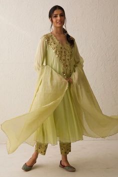 Lime green chanderi anarkali with V neck, monochrome dabka, zari, coin tassel embroidered yoke and sleeve borders. Paired with trousers, dupatta with scalloped cut work hem and inner slip.
Components: 4
Pattern: Embroidered
Type Of Work: Coin Tassels, Dabka and Zari Work
Neckline: V Neck
Sleeve Type: Anarkali: Full Sleeves, Inner Slip: Sleeveless
Fabric: Chanderi
Color: Green
Other Details: 
Embroidered border on pant
Scalloped cut work hem details
Front tassel details
Note: The hair accessory w V Neck Anarkali, Chanderi Anarkali, Dresses Traditional, Indian Look, Aesthetic Dress, Indian Dresses Traditional, Embroidered Border, Embroidery Suits Design, Boutique Dress Designs