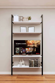 a book shelf with books and pictures on it in an empty room next to a wall