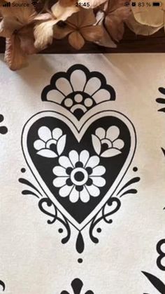 an ornate heart stencil is shown on a white sheet with black and white designs