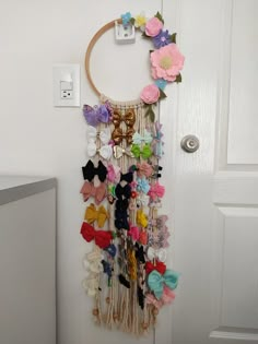 there is a wall hanging made out of hair clips and flowers on the front door