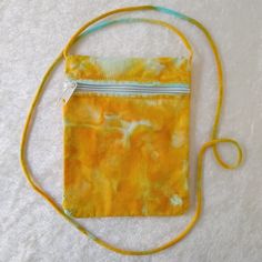 A customer favorite! This little crossbody bag is perfect for corralling keys, cards, cell, and lip balm, keeping your hands free and your stuff secure whether you're working, chasing after kids or pets, or just out for a walk.  Zippered bag measures 7.5 inches tall by 6 inches wide. 32" from bottom of bag to top of strap. 100% cotton canvas, fully lined and finished with a cross-body corded strap.  Handwash recommended; hang to dry. The beauty is in the variations! Every piece we sell is unique -- hand-tied and dyed using high-quality Procion dyes from Dharma Trading Co. Unlike other dyes that sit on top of the fabric and eventually fade with wear, Procion dye bonds with the fabric on a molecular level, so the color you love endures  wash, after wash, after wash!  This bag has been washed Portable Yellow Phone Bag For Everyday Use, Yellow Pouch Phone Bag For Everyday Use, Yellow Crossbody Phone Bag With Cell Phone Pocket, Yellow Crossbody Phone Bag For Everyday Use, Everyday Yellow Crossbody Phone Bag, Procion Dye, Love Endures, Adventure Bags, Zippered Bag