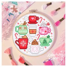 a cross stitch pattern with coffee mugs and other items on the table next to it