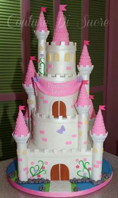 a princess castle cake with pink frosting on top