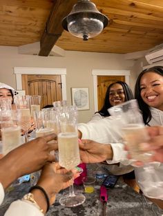 a group of people standing around each other holding wine glasses