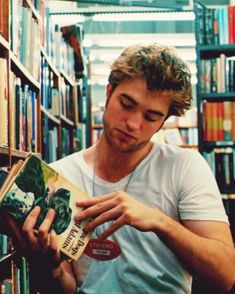 a young man is reading in the library