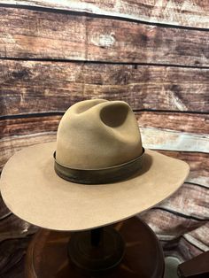 These are vintage Hats unless they state new.  So there will be wear, we try to work the wear out, but sometimes it can't be done. Our team work last hard to insure our products are top of the line to the best of our ability.  this hat is custom, distressed and vintage: a great gift to a cowboy. Custom Brimmed Fedora For Ranch, Artisan Fitted Hats For Ranch, Fitted Artisan Ranch Hats, Custom Brimmed Felt Hat For Ranch, Southwestern Style Fitted Fedora Hat, Fitted Southwestern Fedora Hat, Fitted Southwestern Style Fedora Hat, Custom Fitted Hat For Western-themed Events, Custom Fitted Hats For Western-themed Events