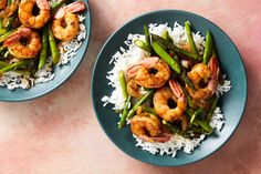 two plates filled with shrimp, asparagus and rice