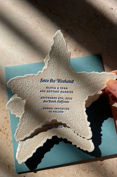 a person holding up a paper cut out of the shape of a star on top of a card