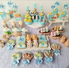 a table topped with lots of cakes and cupcakes covered in fondant animals