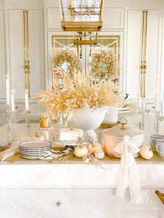 a white table topped with lots of plates and bowls filled with food next to a chandelier