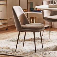 two chairs sitting on top of a rug next to a table