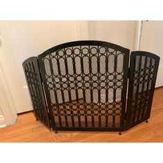 a black iron gate sitting on top of a hard wood floor