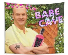 a man holding a pink bottle with the words babe cave on it in front of him